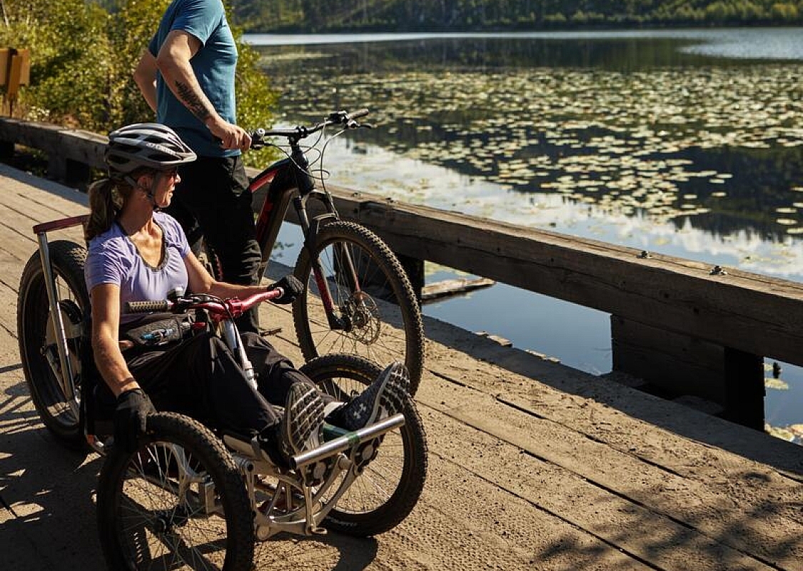 Eine Familie radelt auf den barrierefreien Wegen des Kettle Valley Trail in der Nähe des Chute Lake