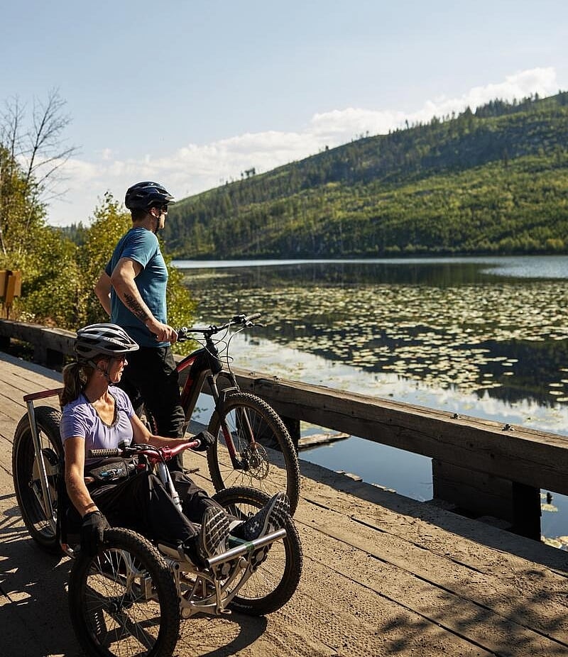 Eine Familie radelt auf den barrierefreien Wegen des Kettle Valley Trail in der Nähe des Chute Lake