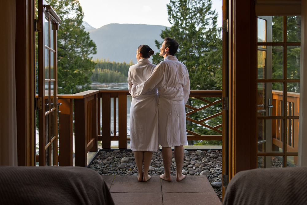 Guests in robes taking in the waterfront view from Sonora Resort on Sonora Island.
