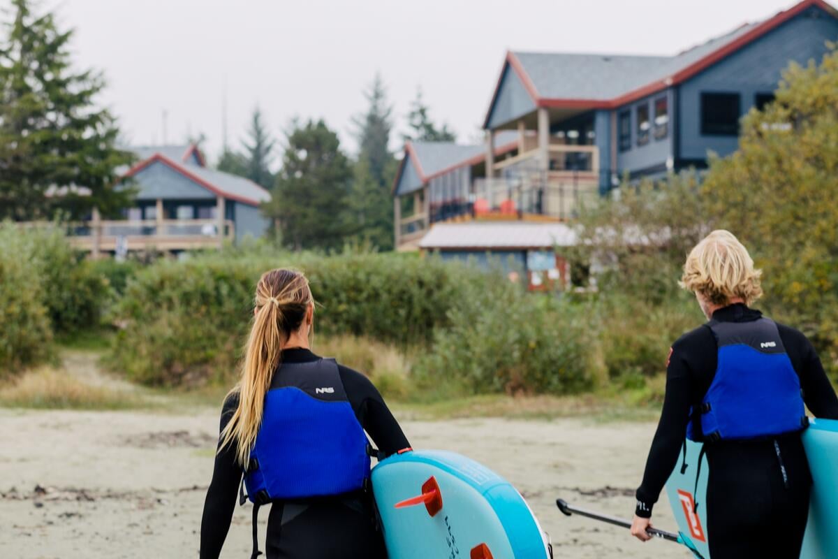Two people with stand up paddleboards at Pacific Sands Beach Resort in Tofino.