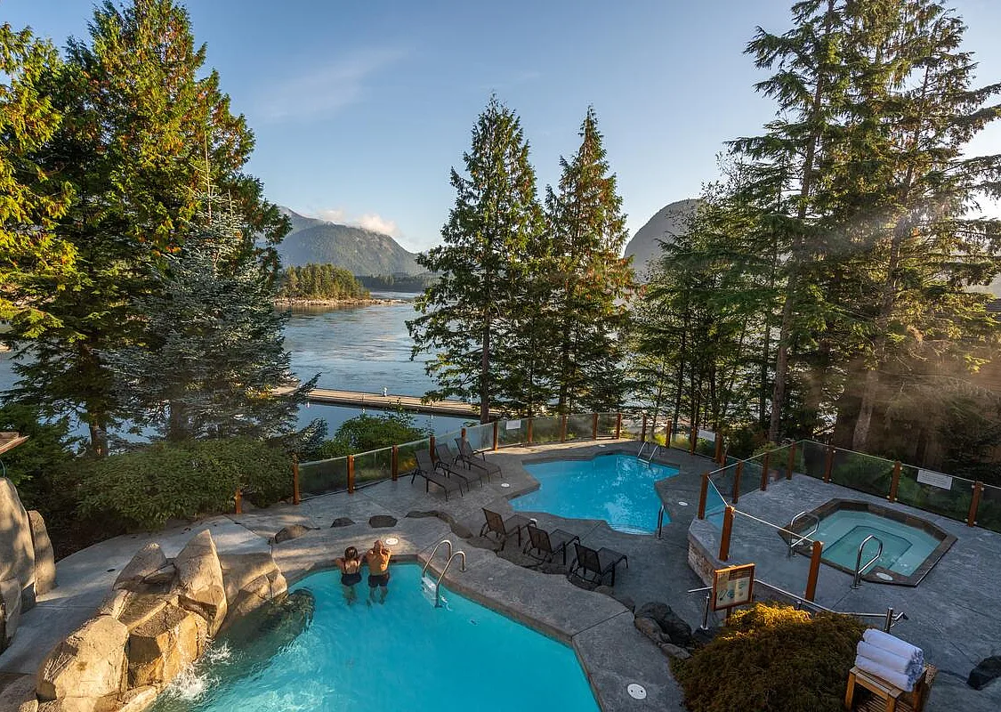 Outdoor pools and spa area surrounded by forest and mountain scenery at Sonora Resort on Sonora Island.