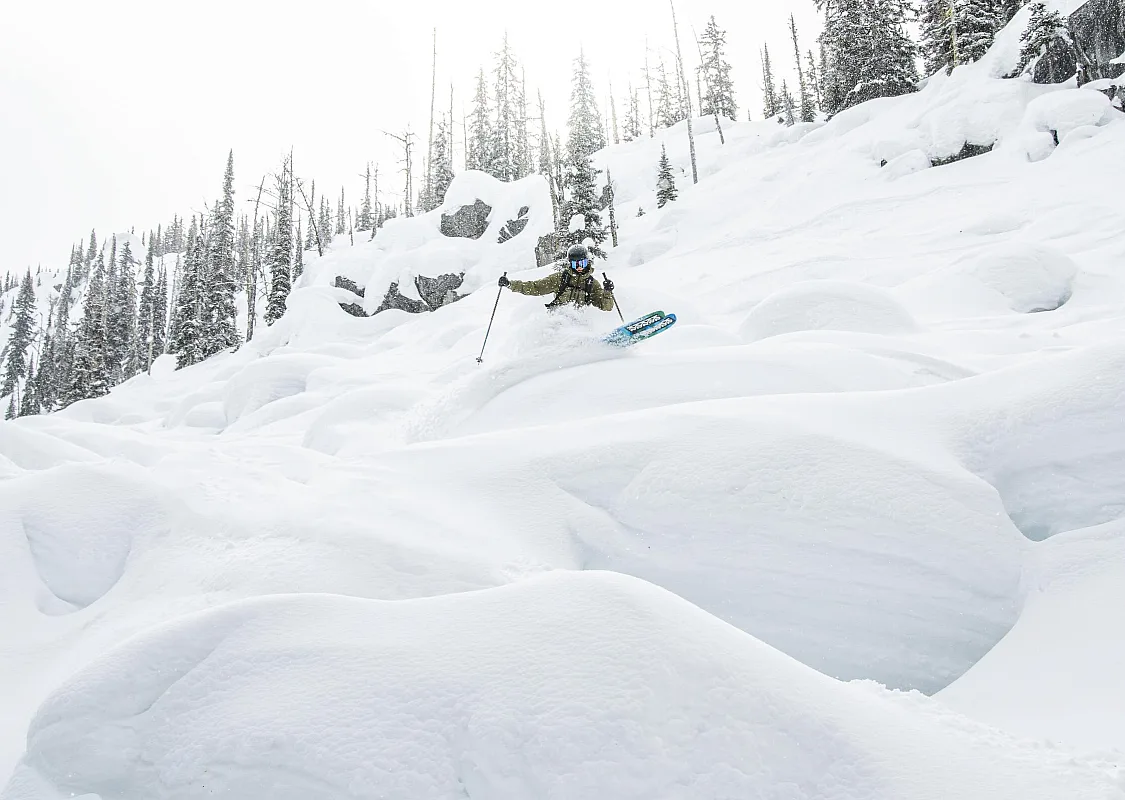 A skier drops through deep powder over snow-covered pillows at Whitewater Mountain Resort in Nelson.
