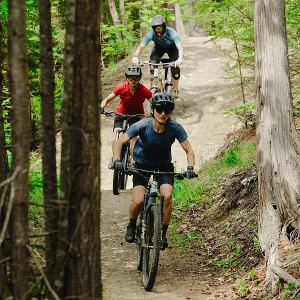 Three mountain bikers riding a forested trail on Mount Abriel in Nakusp.