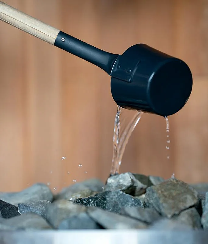 Piedras para sauna y cucharón de agua en la sauna flotante Loyly