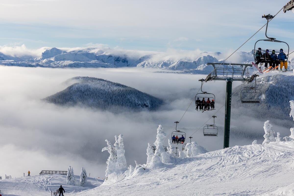 Skiers riding the Eagle Chairlift on a sunny day at Mount Washington above 