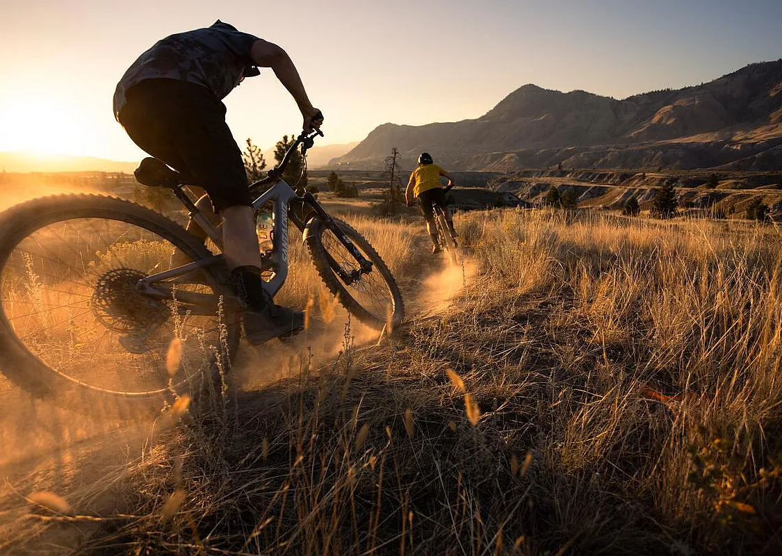 Two mountain bike riders at sunset/golden hour at the Kamloops Bike Ranch.