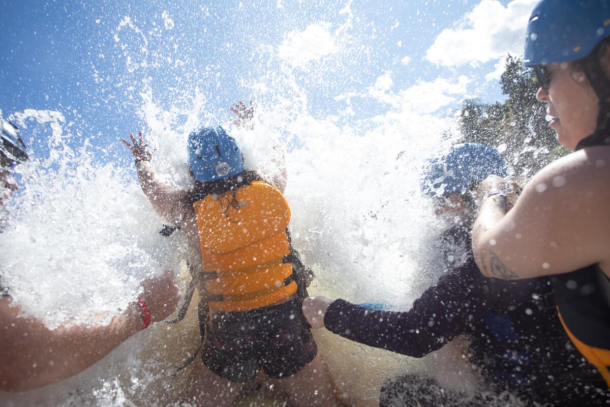 A group getting splashed as they paddle raft at Kumsheen Rafting Resort in Lytton.