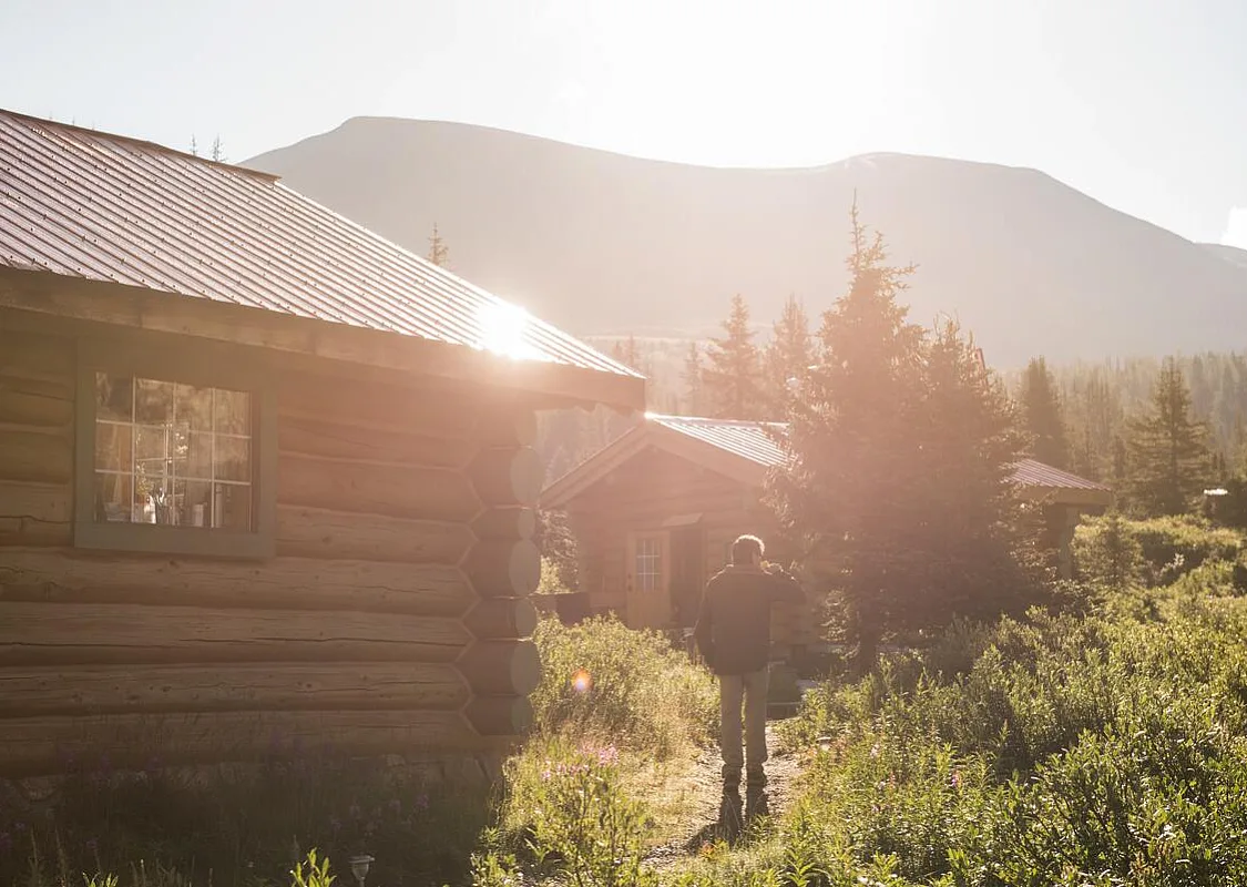 Un excursionista pasa junto a las cabañas de Assiniboine Lodge
